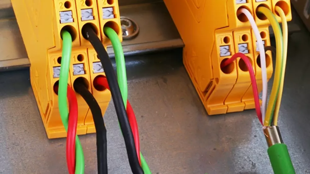Diversi scaricatori combinati gialli montati e cablati su guida DIN, accanto ad altri dispositivi nel quadro elettrico.